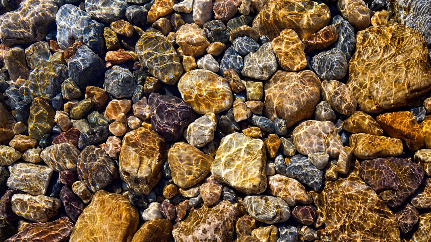 layer of pebbles and rocks on the bottom of a creek bed 