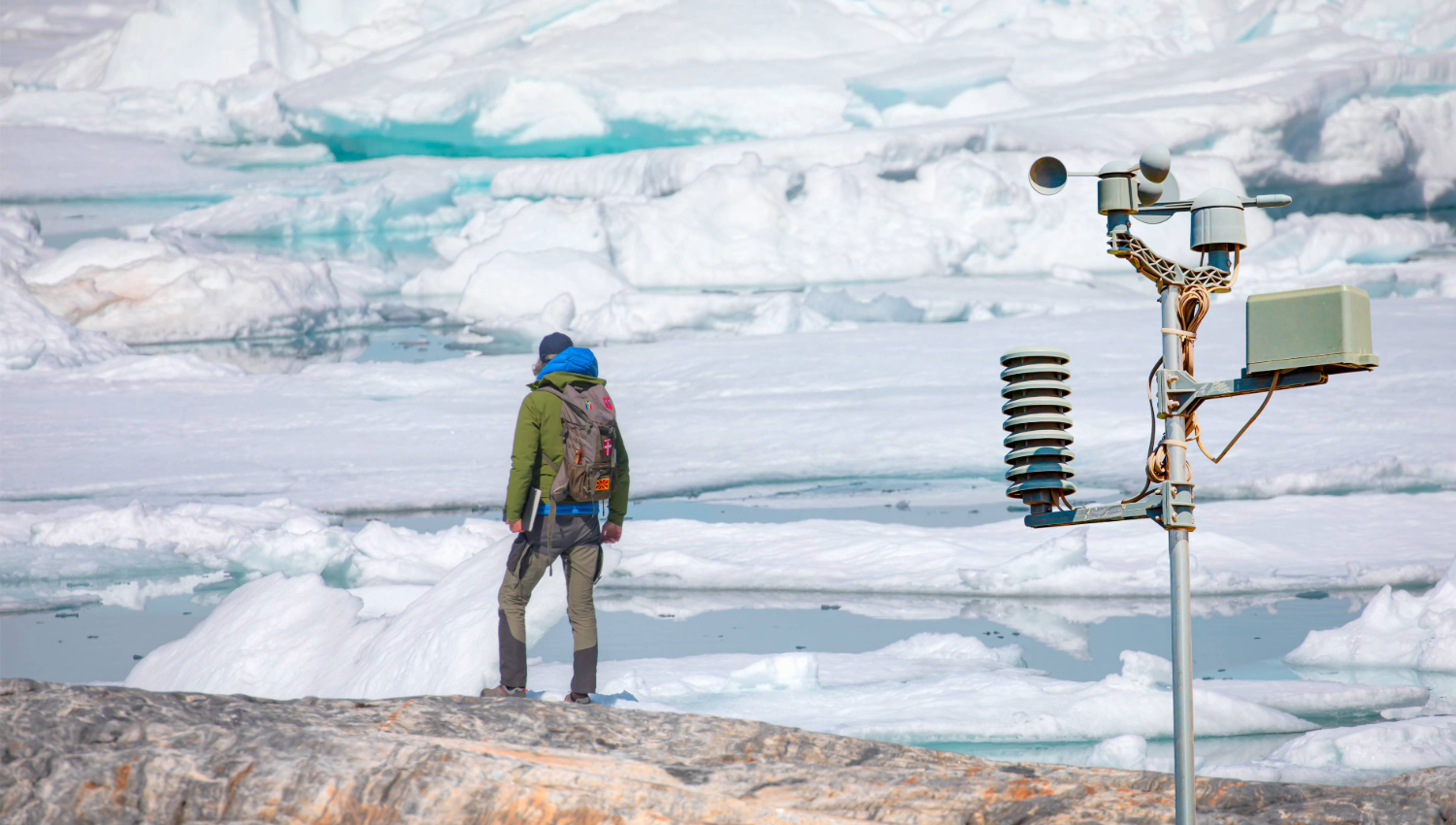 An explorer looks out at a glacier