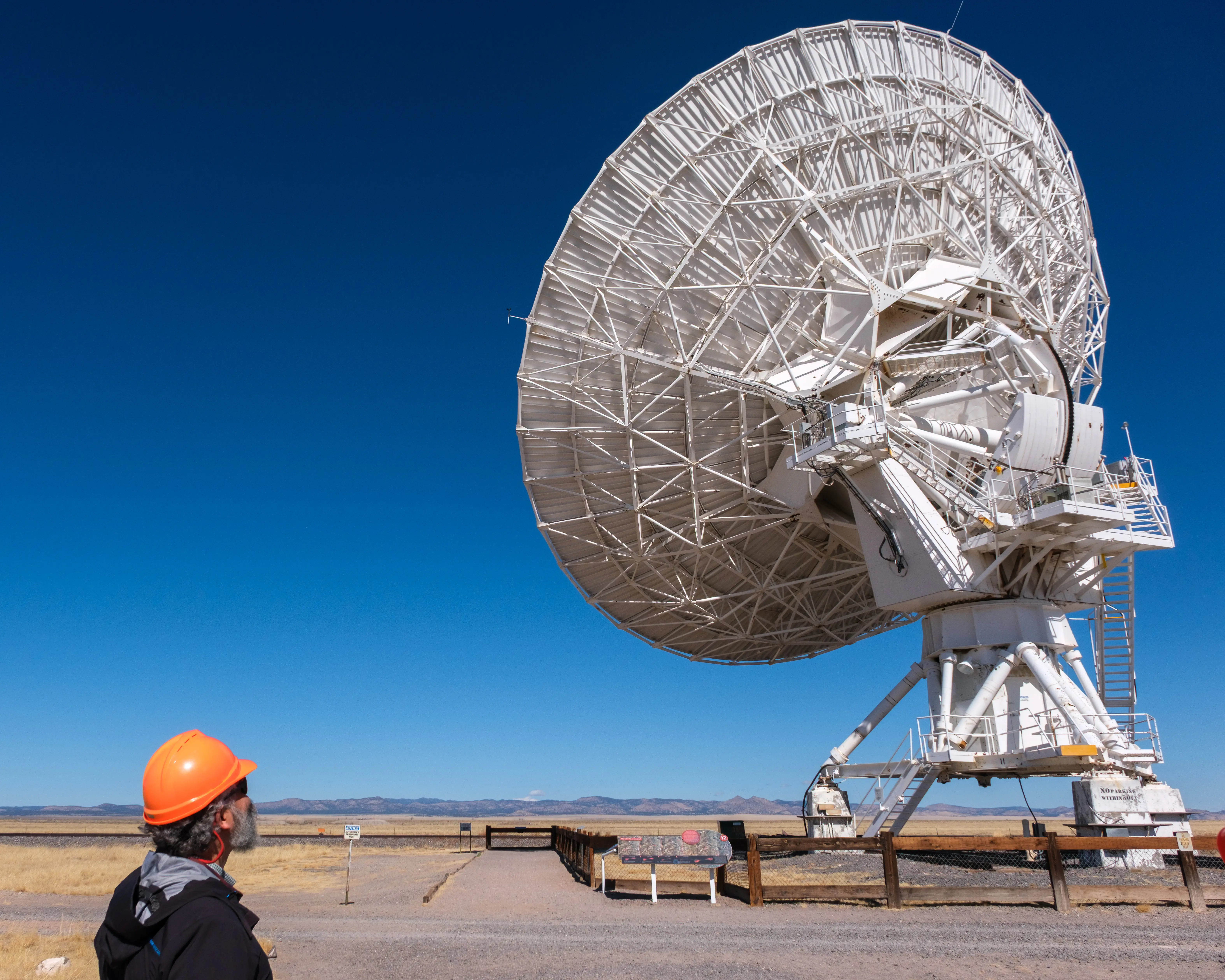 Man next to large telescope